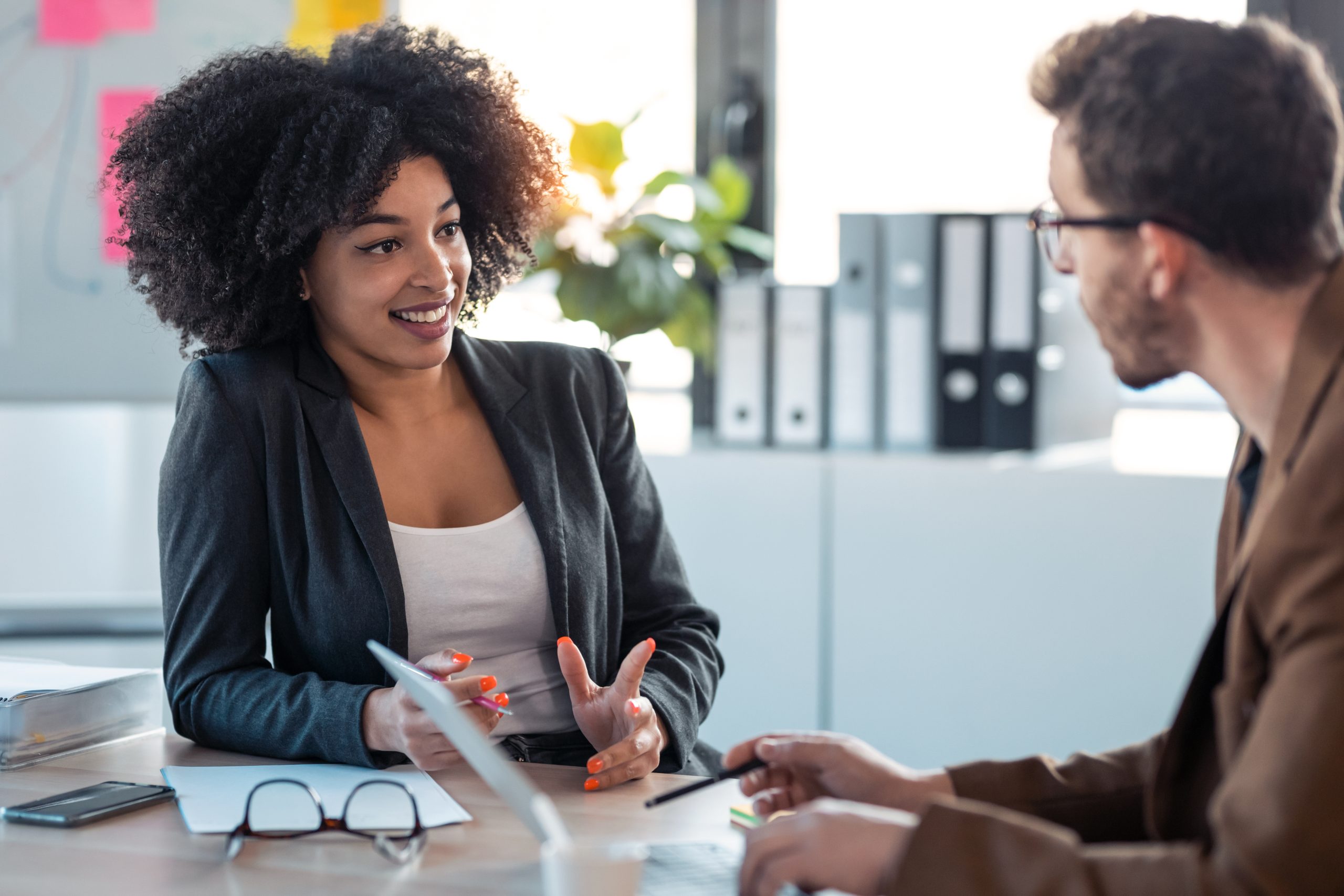 A women and man having a business conversation in the office.